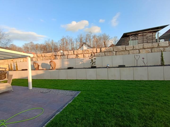 Terrasse mit Rasenfläche und Natursteinmauer