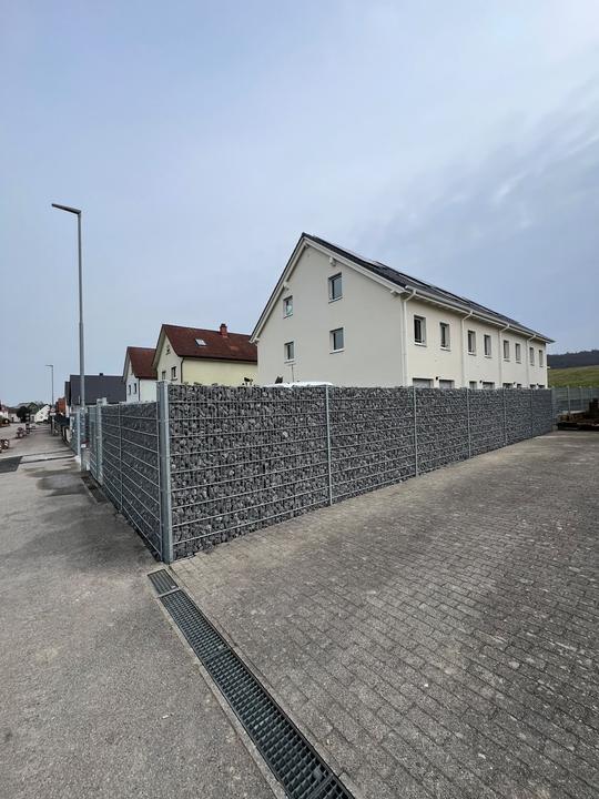 Gabionenzaun entlang der Grundstücksgrenze