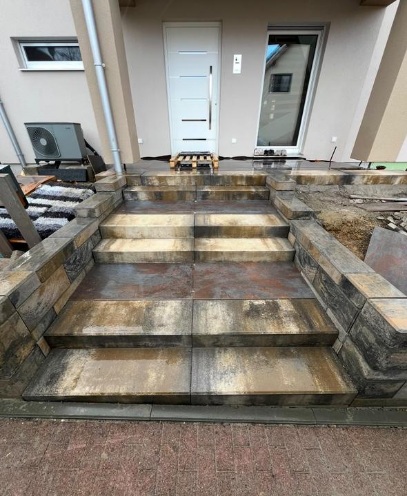 Eingangstreppe mit Blockstufen und Natursteinmauer