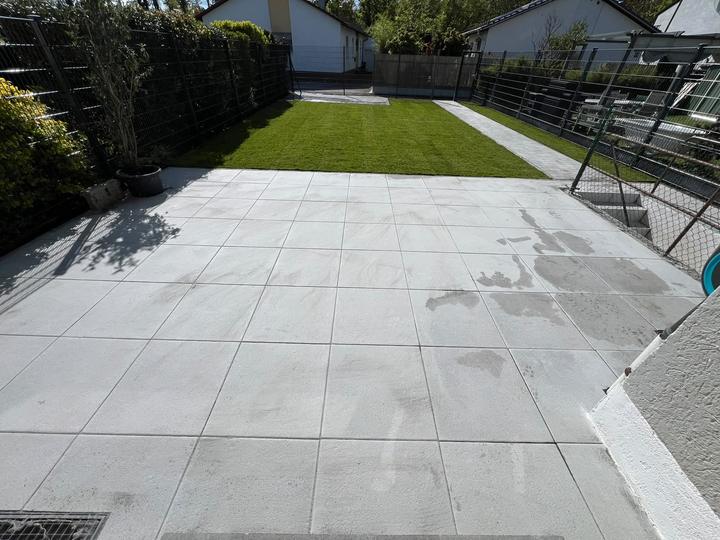 Terrasse mit großen Betonplatten und Rasen