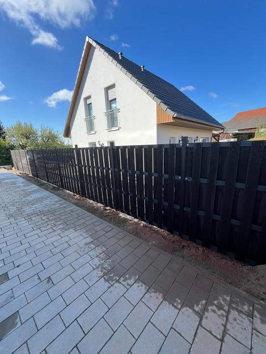 Sichtschutzzaun an einer gepflasterten Zufahrt