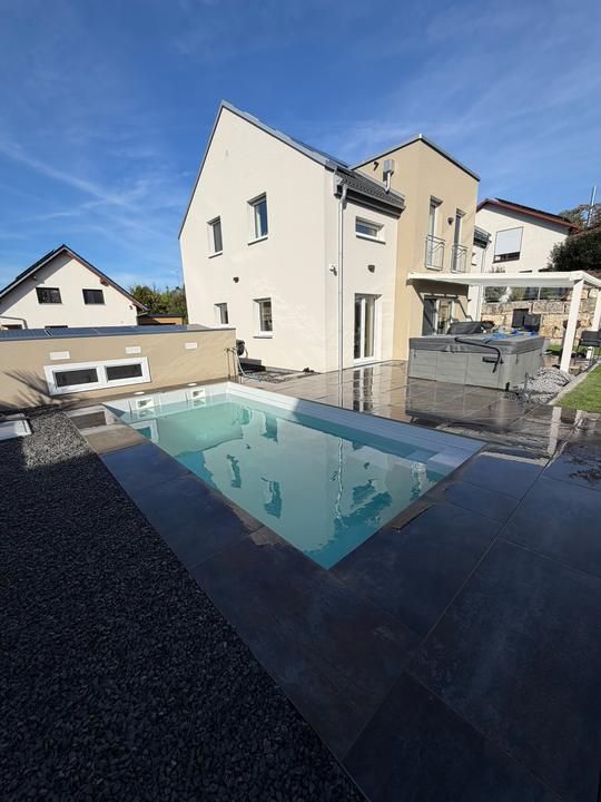 Pool mit Terrassenplatten in Anthrazit an einem Neubau